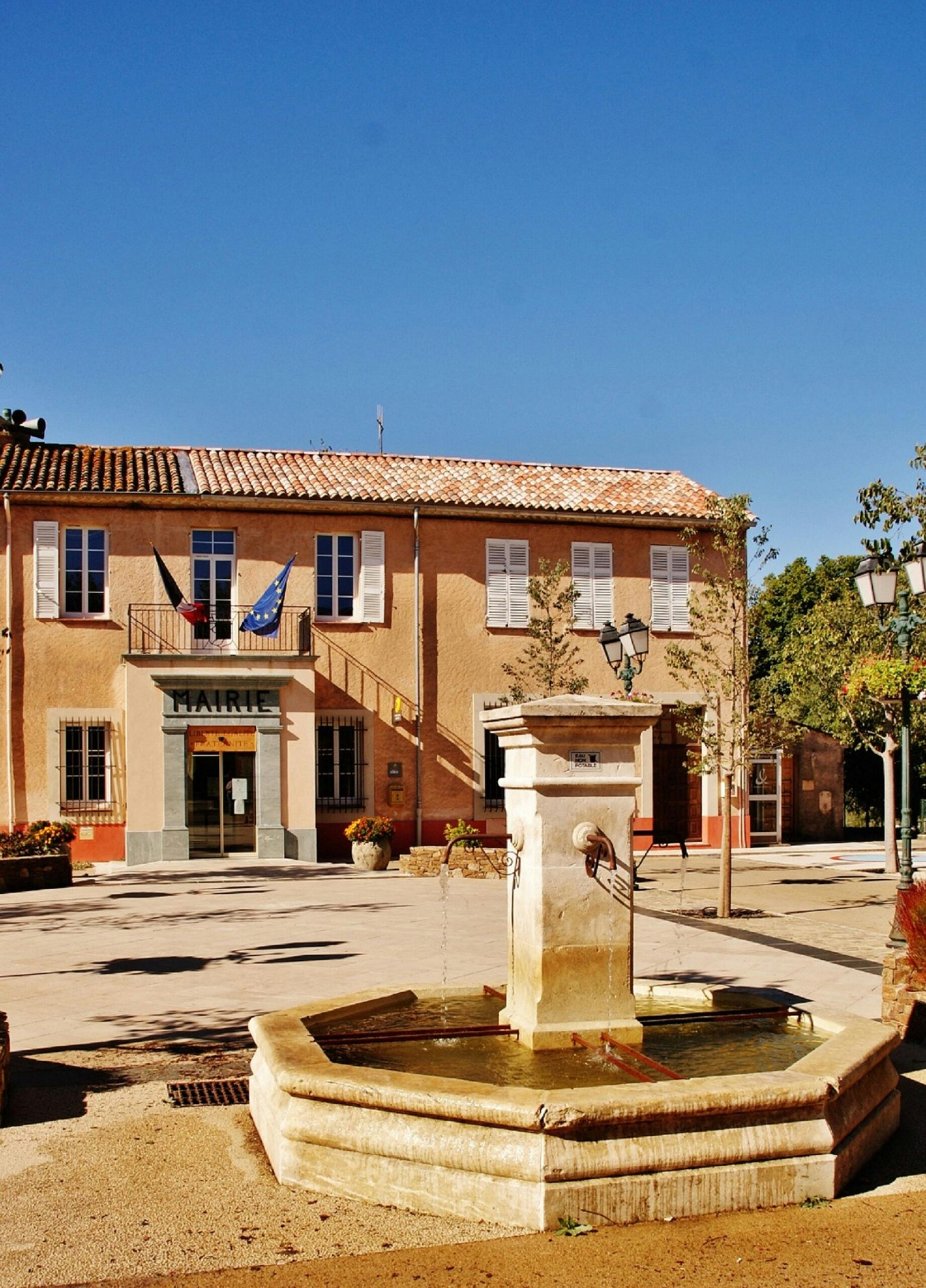 Beautiful water fountain in the sunny village square of La Mole, Provence-Alpes-Côte d'Azur, France.
